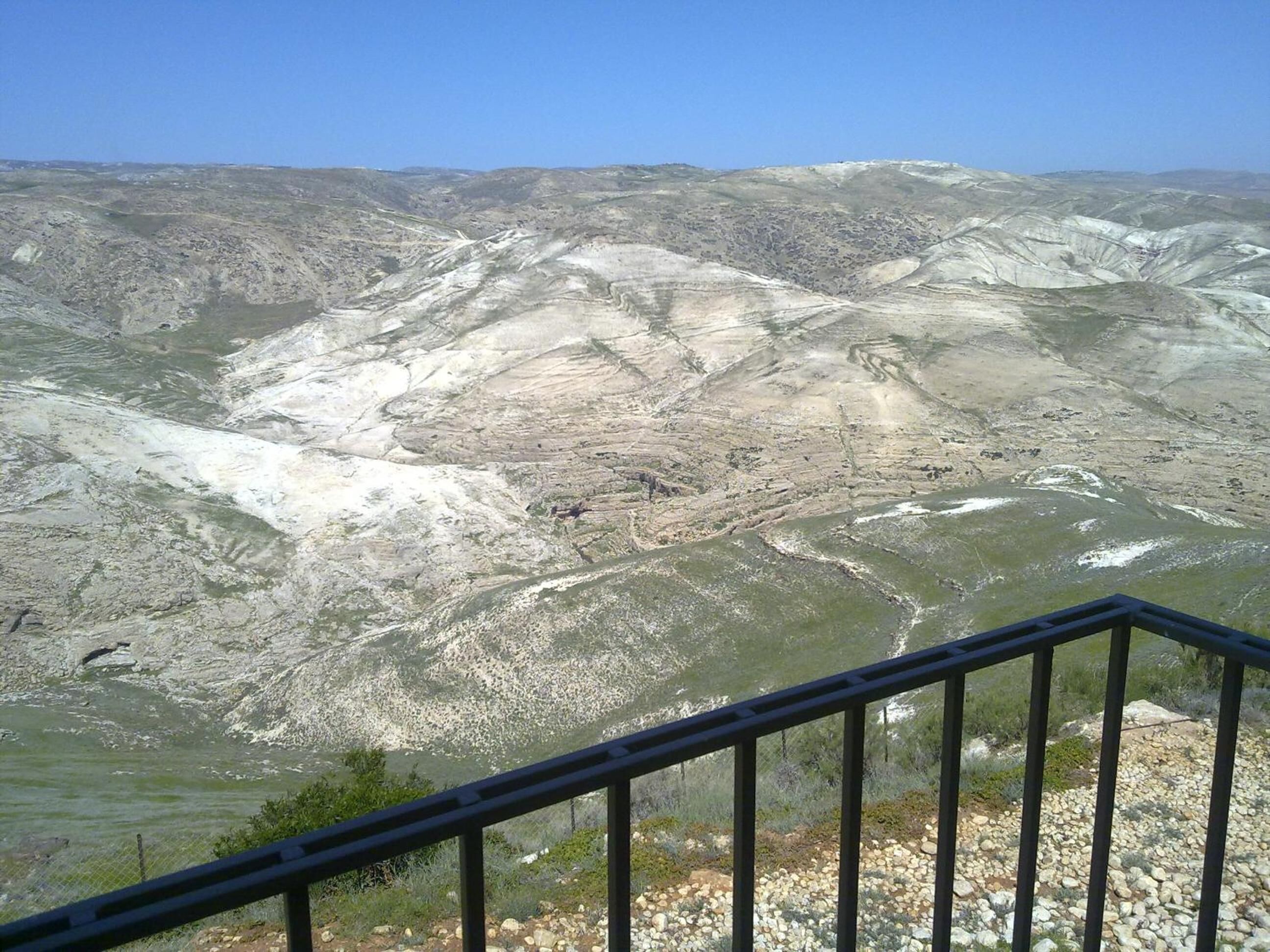 A panoramic view of a mountainous landscape with a clear sky.