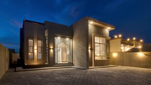 A modern building with a geometric facade, large windows, and a well-lit entrance. - KAY Homes (Ras Al Khaimah)