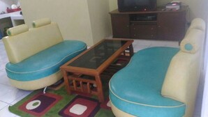 A living room with a sofa set, a coffee table, and a television on a stand.