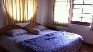 Un dormitorio con cama, cortinas y ventana.