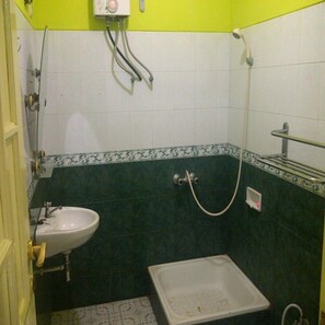 A small bathroom with a white sink, a shower, and a toilet. - Villa Kota Bunga Teratai (Cipanas)