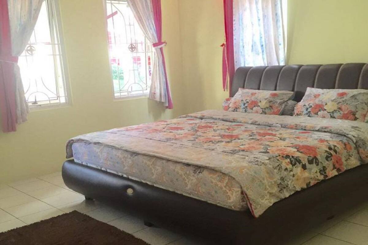 A bedroom with a bed, curtains, and a window.