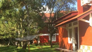 Punainen rakennus, jonka katolla on satelliittiantenni, sijaitsee puustoisella, ruohikkoisella alueella.