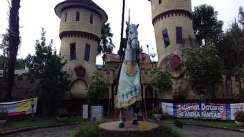 A castle-like structure with two towers and a statue of a horse in the center.