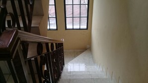 A staircase with a handrail, a window, and a tiled floor. - Villa Kota Bunga Vinca (Cipanas)