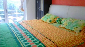 Un dormitorio con cama, almohadas, un armario y una ventana.