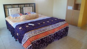 Un dormitorio con cama, armario y ventana.