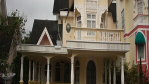 Een tweelaags huis met balkon, veranda en oprit.