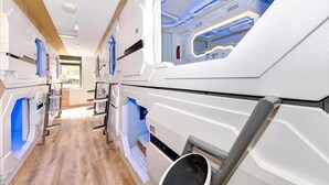 Ein modernes Wohnmobil-Interieur mit Küchenbereich, Schlafgelegenheiten und einem Badezimmer.
