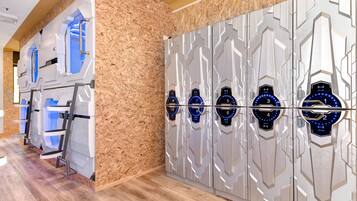 Fila de taquillas con puertas numeradas, pared de madera y suelo de madera.