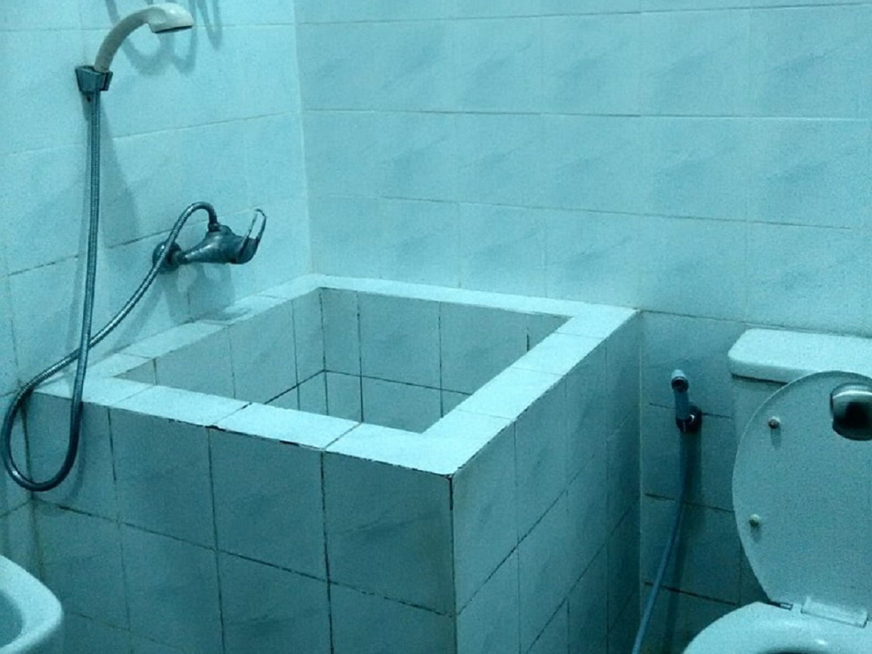 A bathroom with a shower, toilet, and sink.