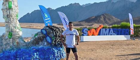 A person standing on a blue mat with a sign that reads "SWIMMASTER" in the background.