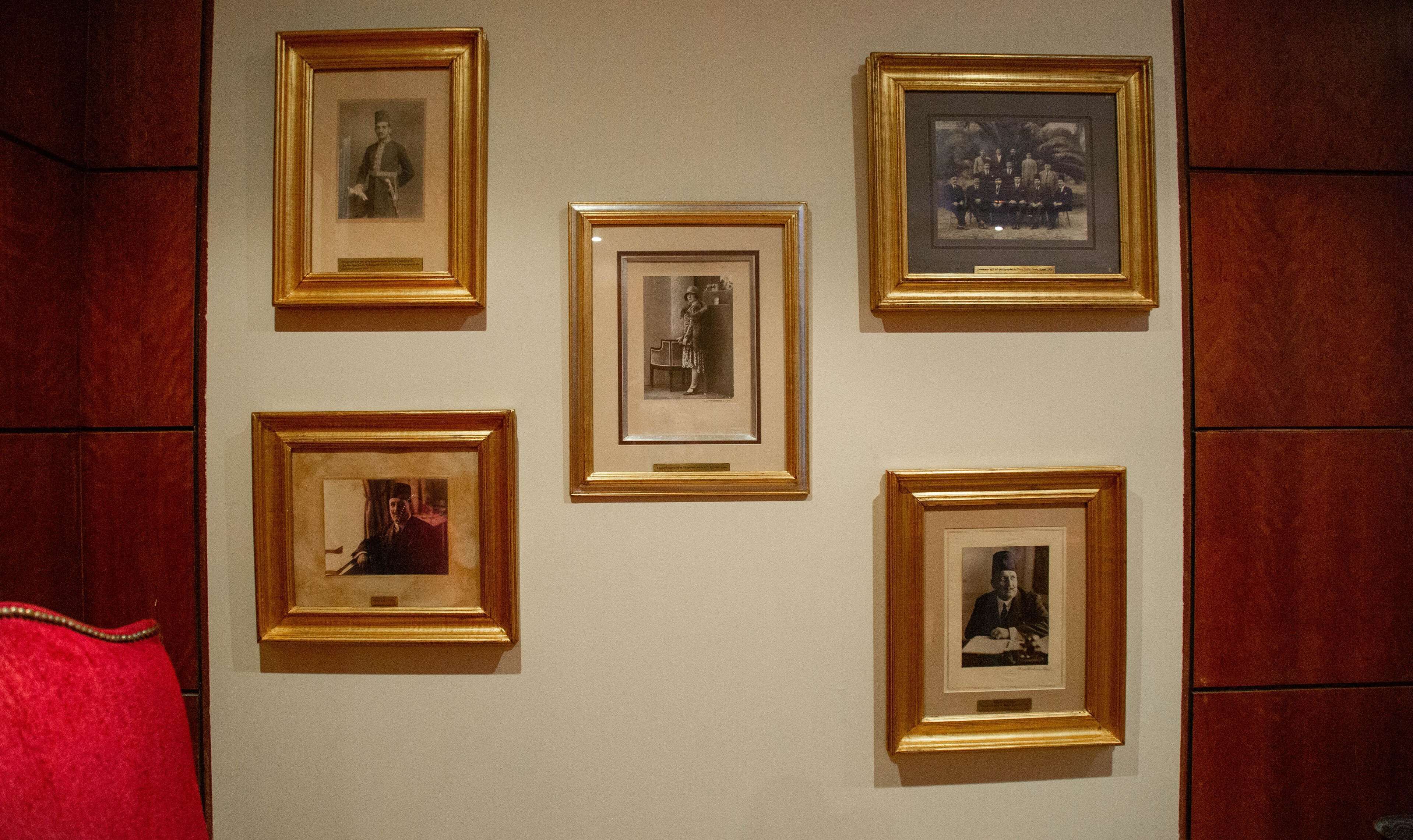 A wall with five framed photographs.