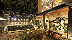 An outdoor bar area with a counter, seating, and potted plants. - Nepali Ghar Hotel, Thamel – Your Home in Nepal (Kathmandu)