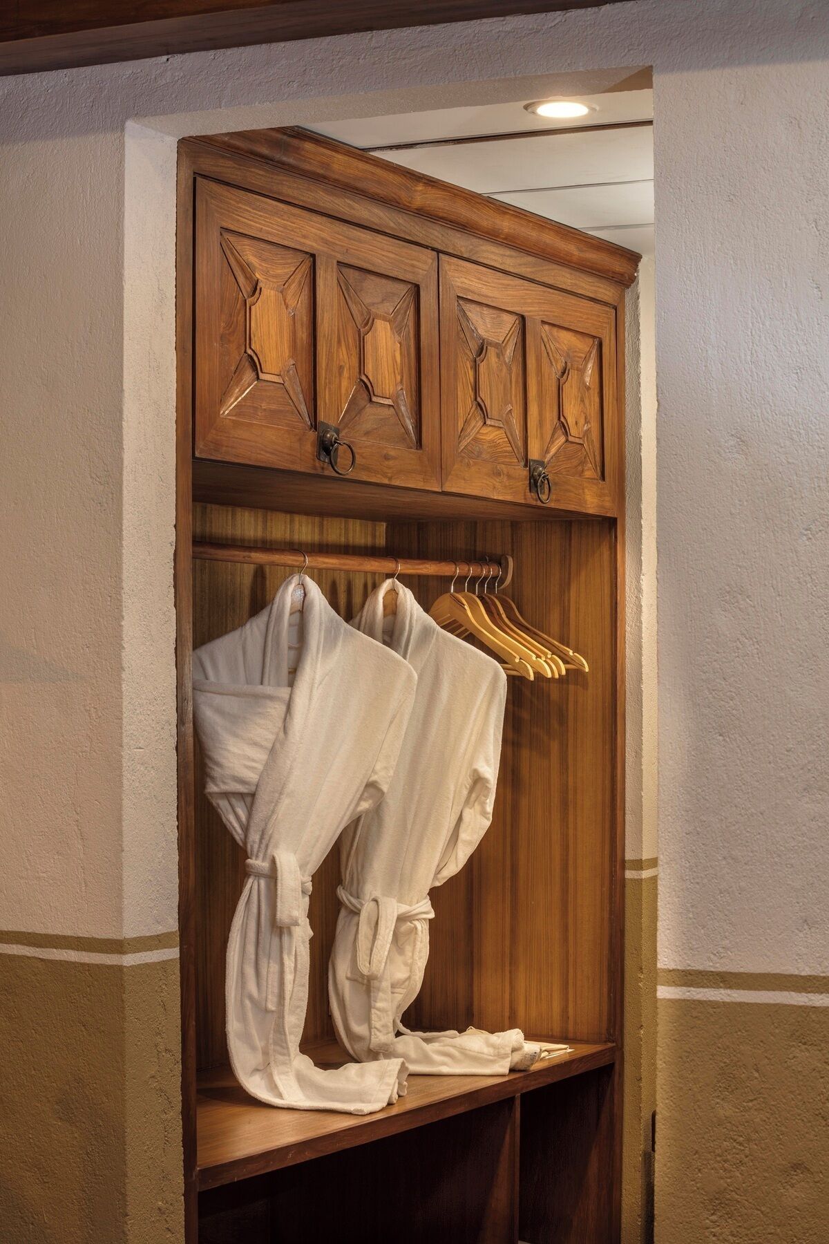 A wooden wardrobe with a mirror and a hanging rack for clothes.