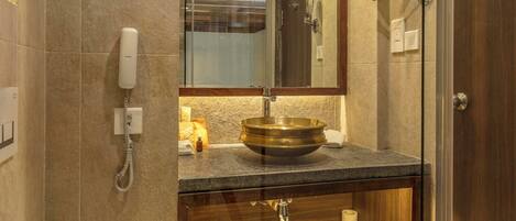 A modern bathroom with a glass-enclosed shower, a vanity with a sink and mirror, and a bathtub with a towel.