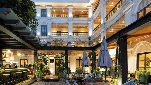 A spacious indoor courtyard with a bar area, seating, and potted plants. - Nepali Ghar Hotel, Thamel – Your Home in Nepal (Kathmandu)