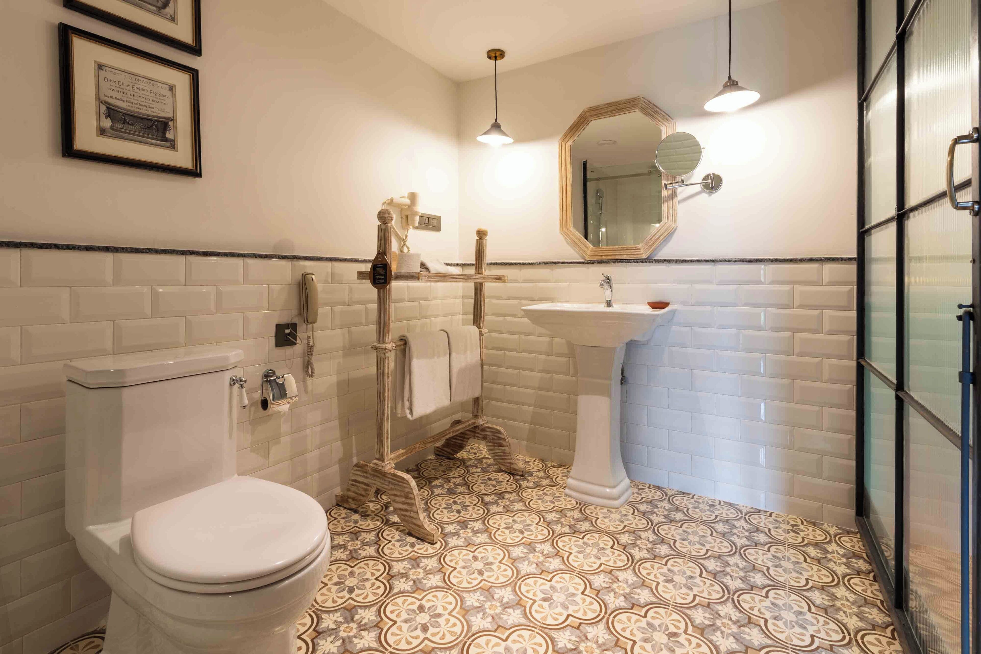 A bathroom with a toilet, sink, and mirror.