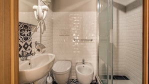 Une salle de bain moderne avec une douche à parois de verre, un bidet, des toilettes et un lavabo.