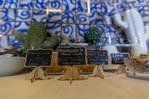 A café with chalkboard signs listing menu items such as 'Marinellata di Arance Amare' and 'Marinellata di Arance Dolce'. - Borgo Giallonardo (Realmonte)