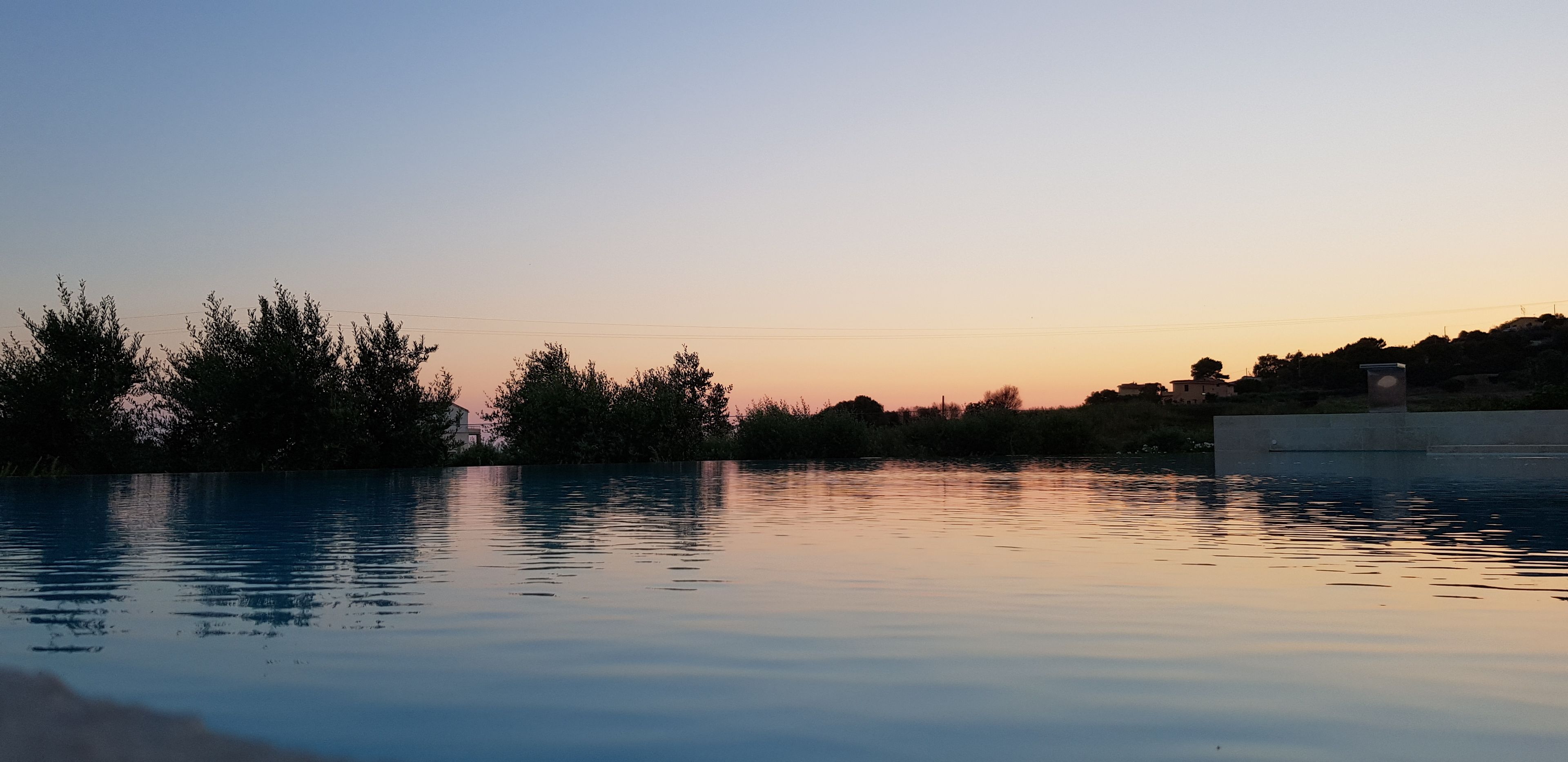Un cuerpo de agua tranquila reflejando el cielo al atardecer.