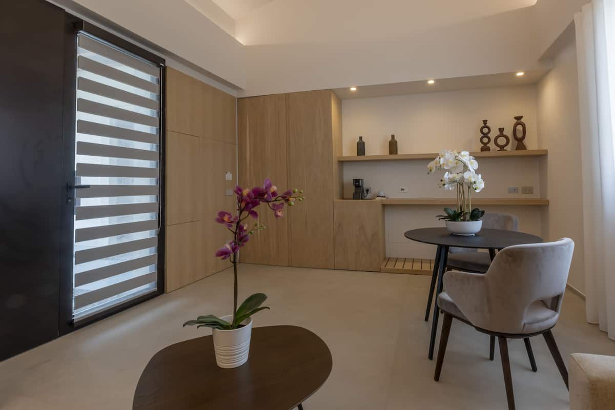 Une cuisine moderne avec des meubles en bois, une table à manger avec des chaises et une orchidée en pot.