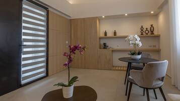Eine moderne Küche mit Holzausstattung, einem Esstisch mit Stühlen und einer Topfpflanze mit Orchidee.