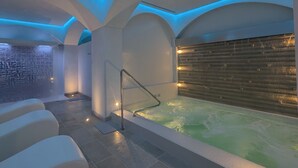 Un área de spa con hidromasaje, asientos y una pared de madera.