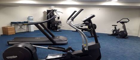 A gym with treadmills, an elliptical, and a stationary bike.
