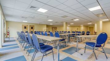 Una sala de conferències amb diverses taules i cadires, disposades en files.