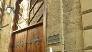A large wooden door with a metal handle and a small plaque on the wall. - Town Gates Hotel (Baku)