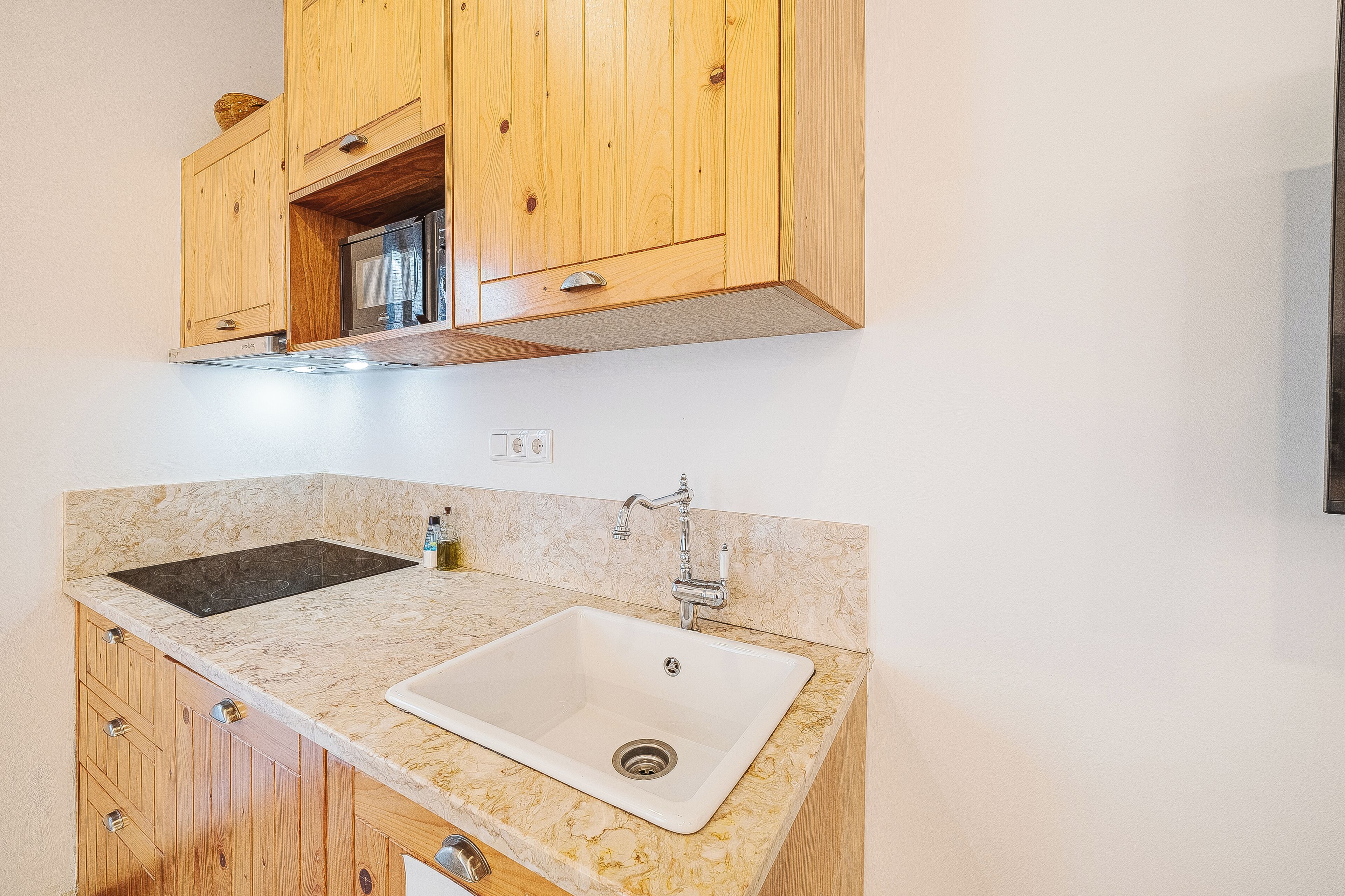 Eine Küche mit Holzausbau, einer Spüle mit zwei Becken und einer Marmorarbeitsplatte.