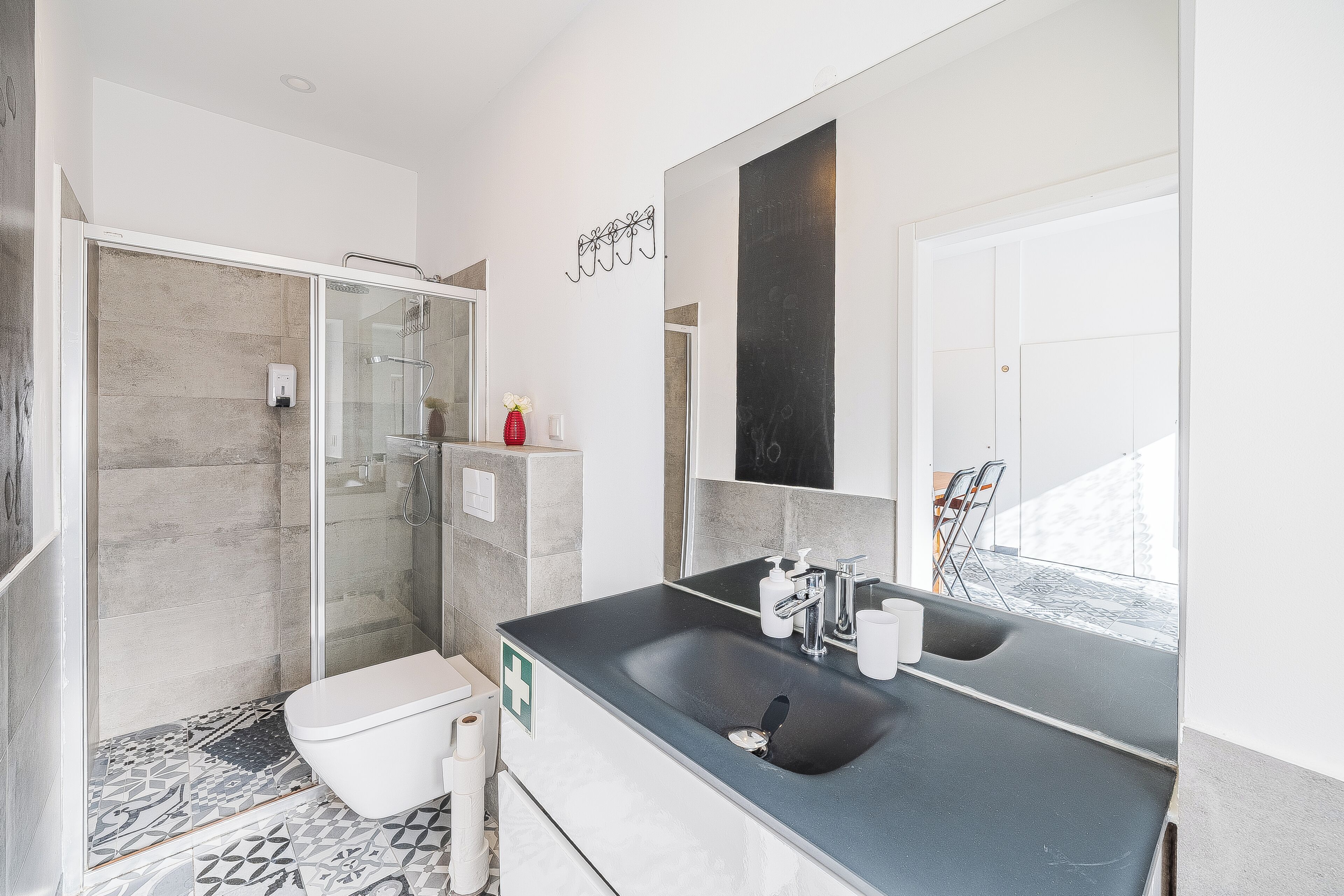 A modern bathroom with a shower, toilet, and sink.