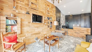 Un interior de madera con un sofá, una mesa, un televisor y una chimenea.