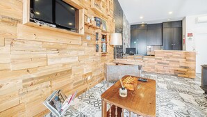 Un interior moderno con paredes de madera, un televisor de pantalla plana, una mesa de madera y un piso con diseño.