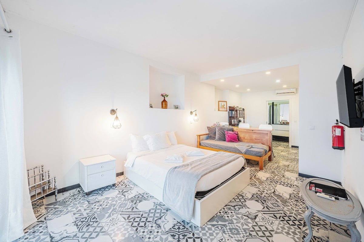 Un dormitorio con cama, mesita de noche y suelo estampado.