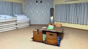 Una habitación de hotel con una cama, una mesa con sillas, un espejo y un equipo de aire acondicionado.