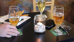 Eine Bar mit einer Theke, Biergläsern, einer Kerze und Schlüsseln auf einem Untersetzer.
