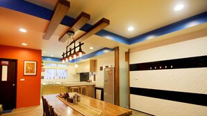 A modern kitchen with a wooden dining table, built-in appliances, and a decorative ceiling light fixture. - Park 61 B&B (Luodong)
