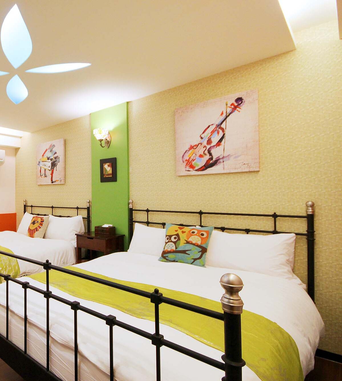 A hotel room with a bed, a nightstand, and a wall with two paintings.