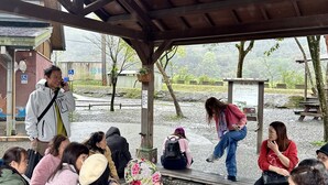 A covered outdoor area with a wooden bench seating arrangement. - Park 61 B&B (Luodong)