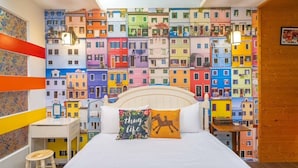 A bedroom with a colorful cityscape mural on the wall, a bed with two pillows, a nightstand, and a stool. - Park 61 B&B (Luodong)