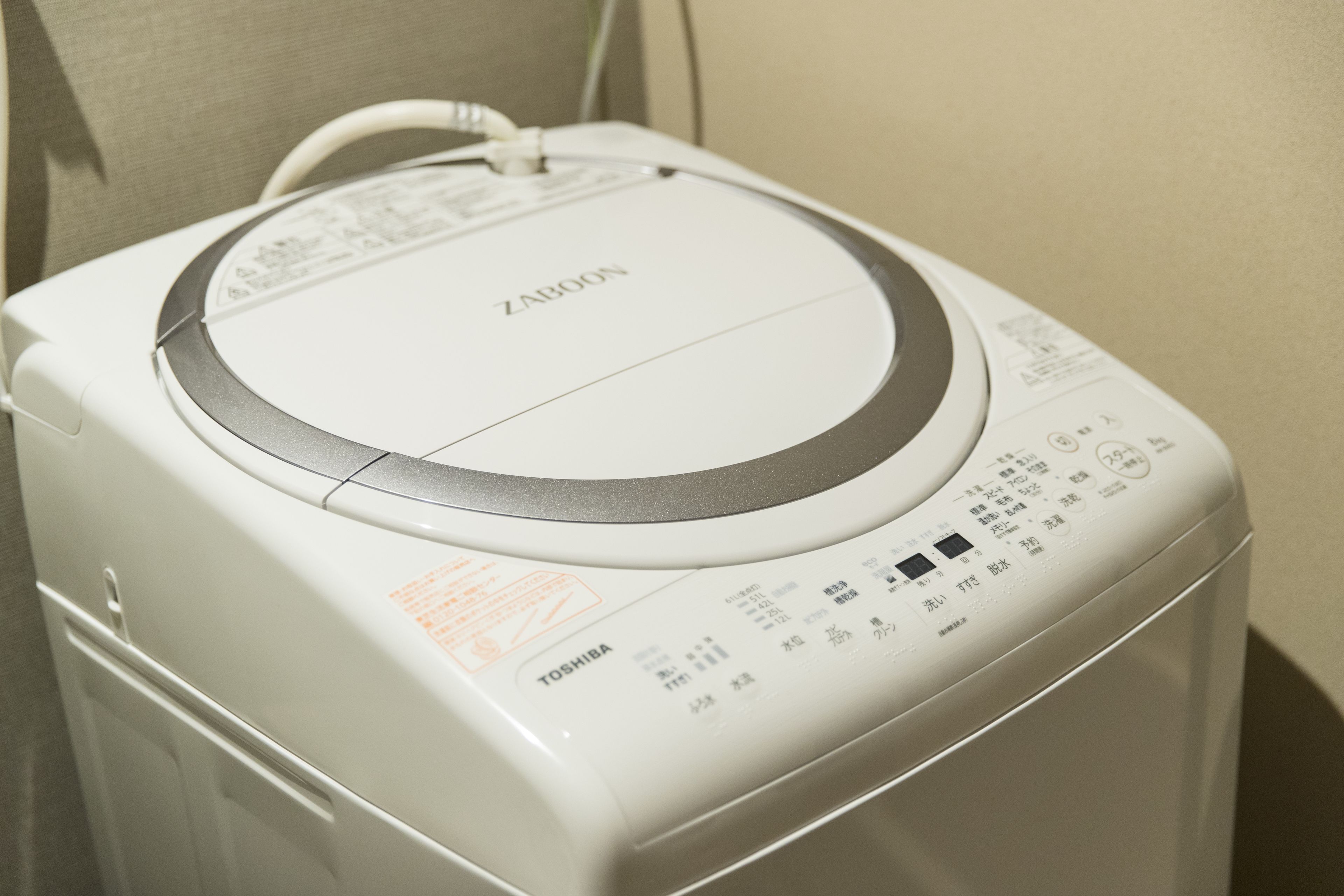 A white washing machine with a control panel and a power cord.