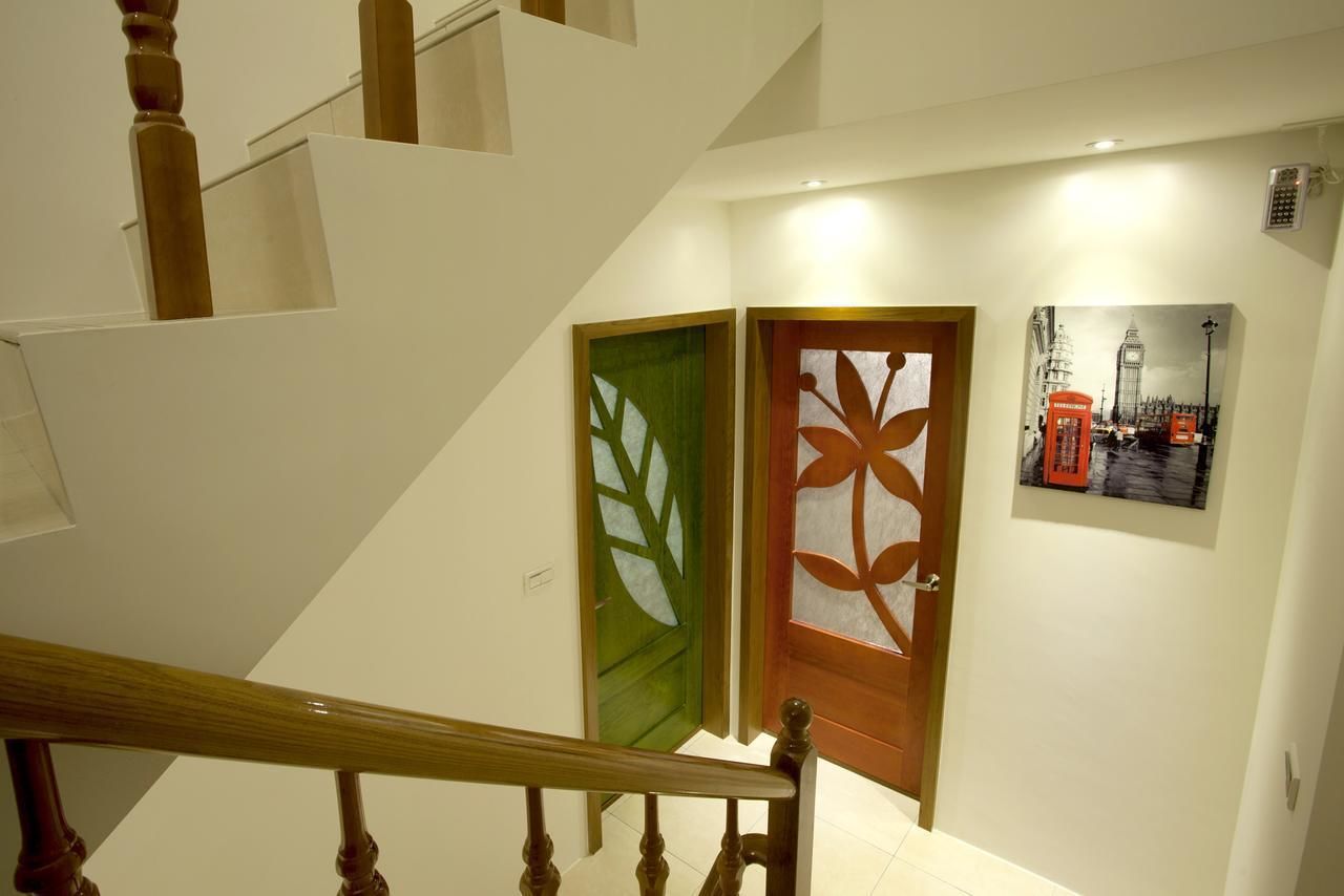 A staircase with wooden handrails and a green door with a leaf pattern.