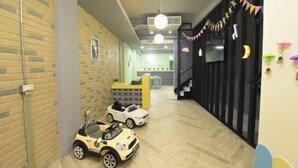 A hallway with a brick wall, a staircase, and a play area with toy cars. - 23 Here B&B (Hualien City)