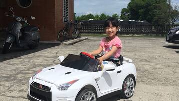 Un niño en un coche de juguete blanco.