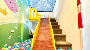 A children's play area with a slide and ball pit.