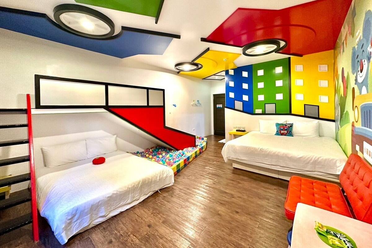 A children's room with bunk beds, a ball pit, and colorful wall decorations.