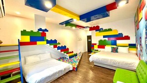 A children's room with two beds, a ball pit, and colorful wall decorations.