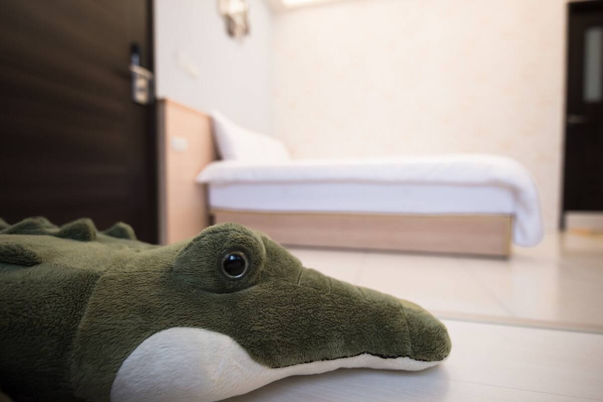 Un cocodrilo de peluche sobre un suelo de madera.